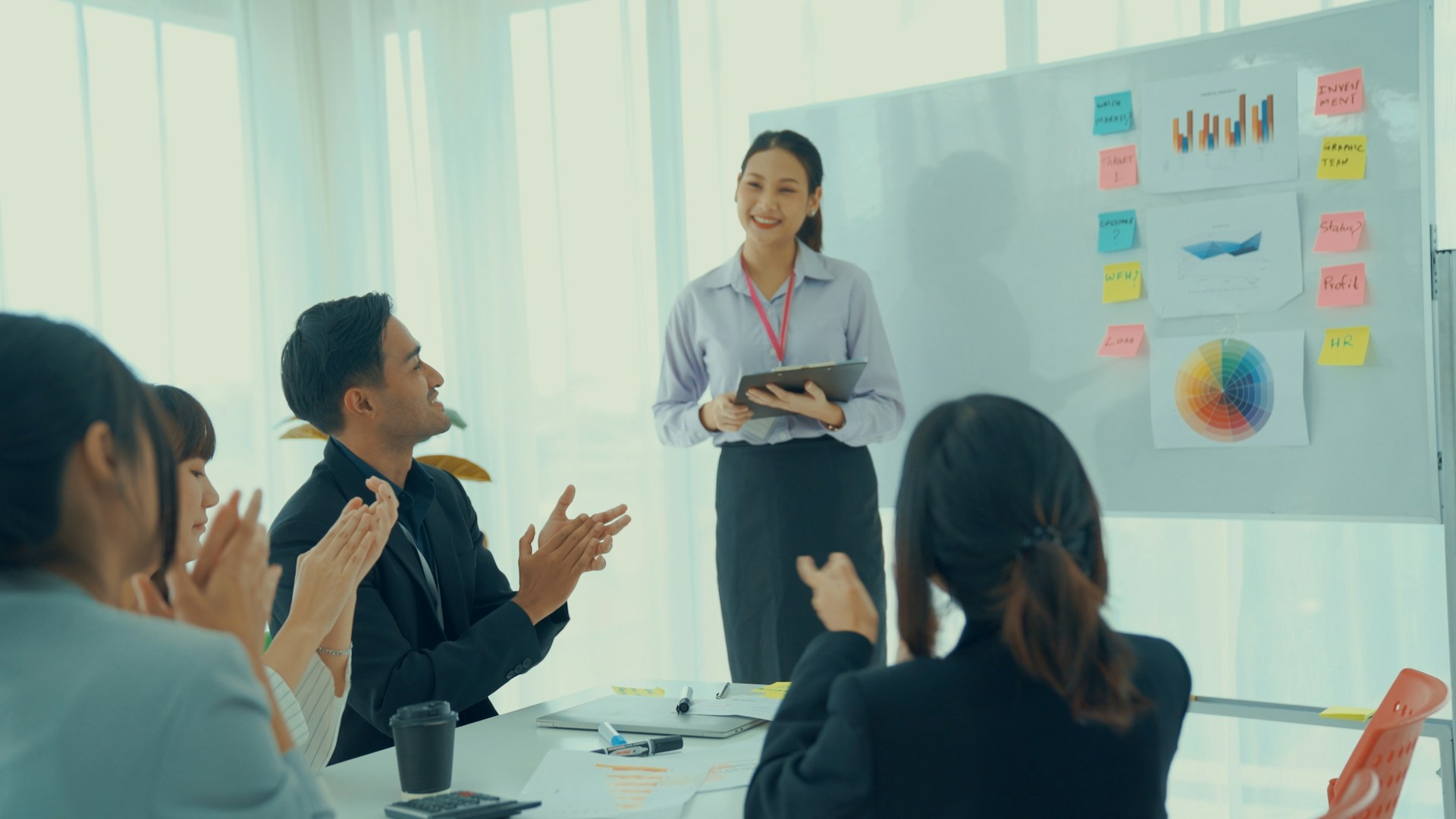 A woman delivers a presentation to a group of attentive participants.